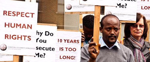 Photo of people carrying protest signs for human rights