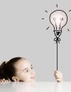 Girl holding the end of a graphic drawn string attached to a light bulb shaped like a balloon