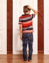 Young boy stands scratching head as he faces three white doors
