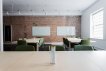 Empty classroom with tables, chairs, and 2 white boards hanging on a brick walll