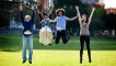 Two girls and two guys of different ethnicities jumping in the air with their hands up